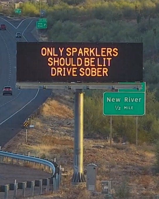 An Arizona DOT electronic freeway sign near New River warns holiday motorists — “Only sparklers should be lit — drive sober” — part of safety messaging ahead of the July 4th weekend.