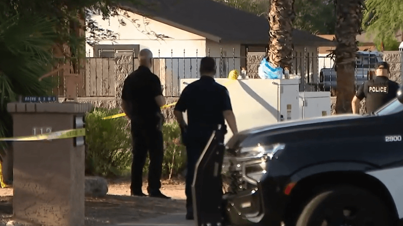 Shows: Gilbert police officers stand behind yellow crime-scene tape outside a neighborhood residence as investigators work the scene of the fatal stabbing that left three people dead.