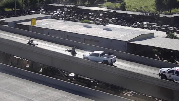 Aerial view of the Loop 101 to Loop 202 transition ramp showing a crashed motorcycle, a pickup truck and emergency presence as authorities work the scene during the ramp closure.