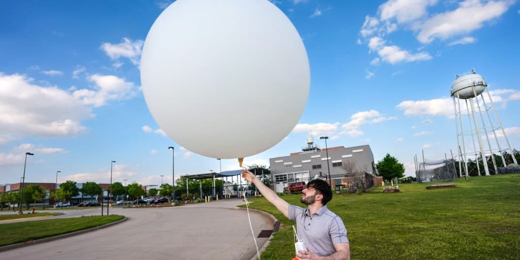 National Weather Service staffer holds a weather balloon prior to release — launches that have been paused at Tucson’s office amid helium supply issues.
