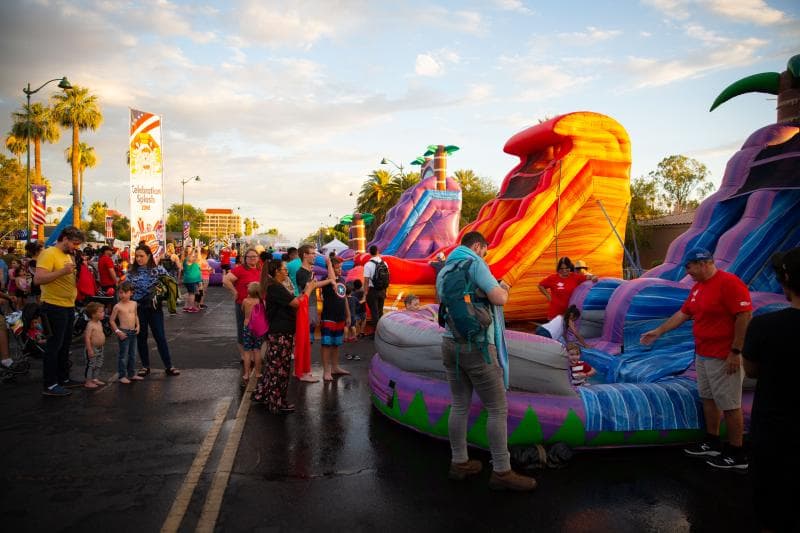 Families line up at colorful inflatable waterslides in the Celebration Splash Zone — a popular way to cool off during the July 4 festival.