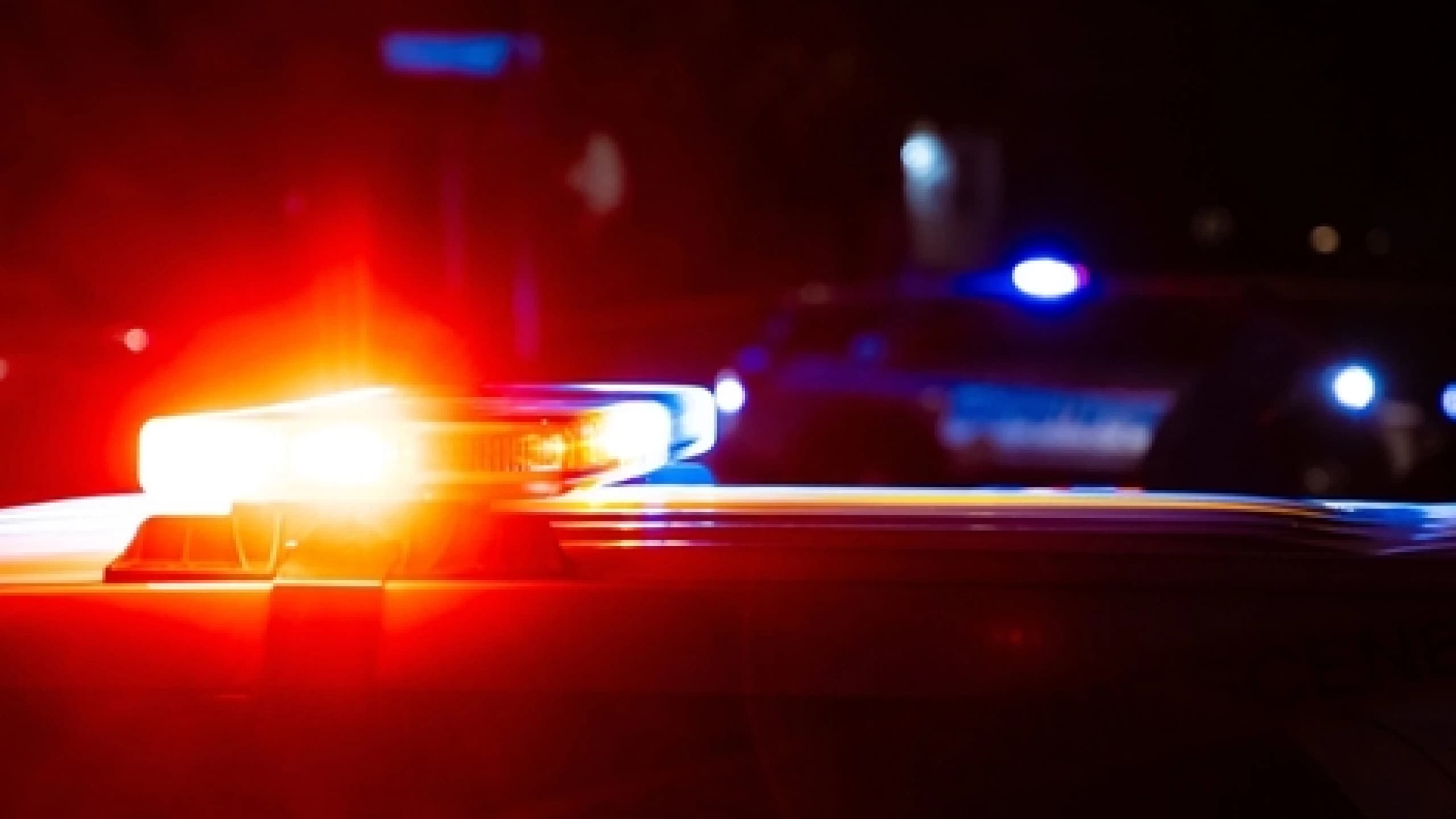 Police vehicle emergency lights flash at night as troopers investigate and clear a crash that closed eastbound I-10 near Vail.