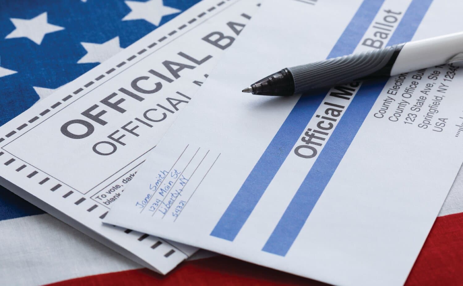Official ballot and pen atop an American flag, illustrating mail-in and early voting in the Arizona CD5 Democratic primary.