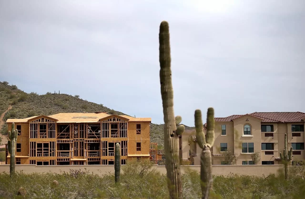 New residential construction with saguaro cacti in the foreground on the outskirts of Phoenix, illustrating local housing development amid a shortage for middle‑income buyers.