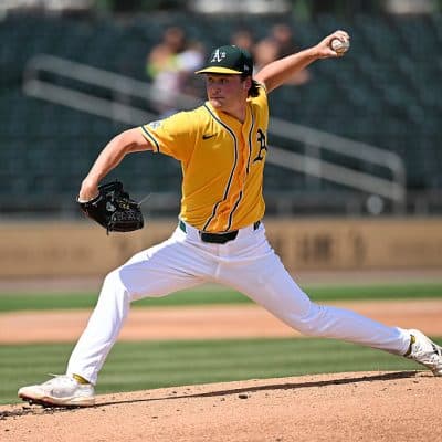 Oakland Athletics pitcher in mid-delivery on the mound, representing the arms among the prospects discussed in Just Baseball’s Top 100 midseason update.