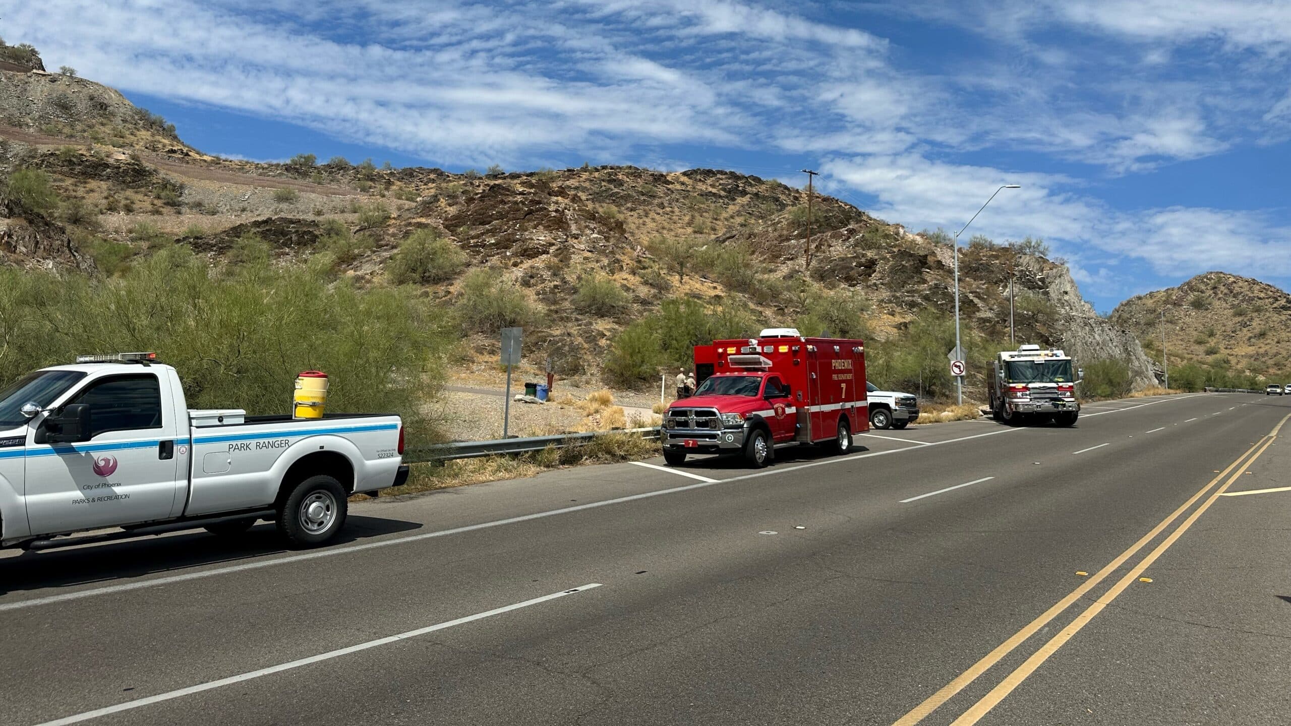 Park ranger and Phoenix Fire vehicles staged along a Scottsdale road near the trailhead as crews responded to a heat-exhaustion call.