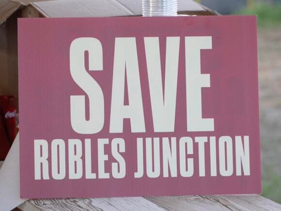 A 'Save Robles Junction' protest sign displayed at a community gathering opposing the proposed Three Points solar farm.