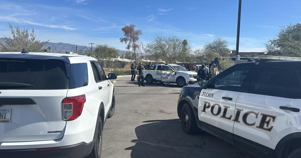 Tucson Police and Community Service vehicles parked at the cleanup site as officers support crews removing trash and coordinating outreach.