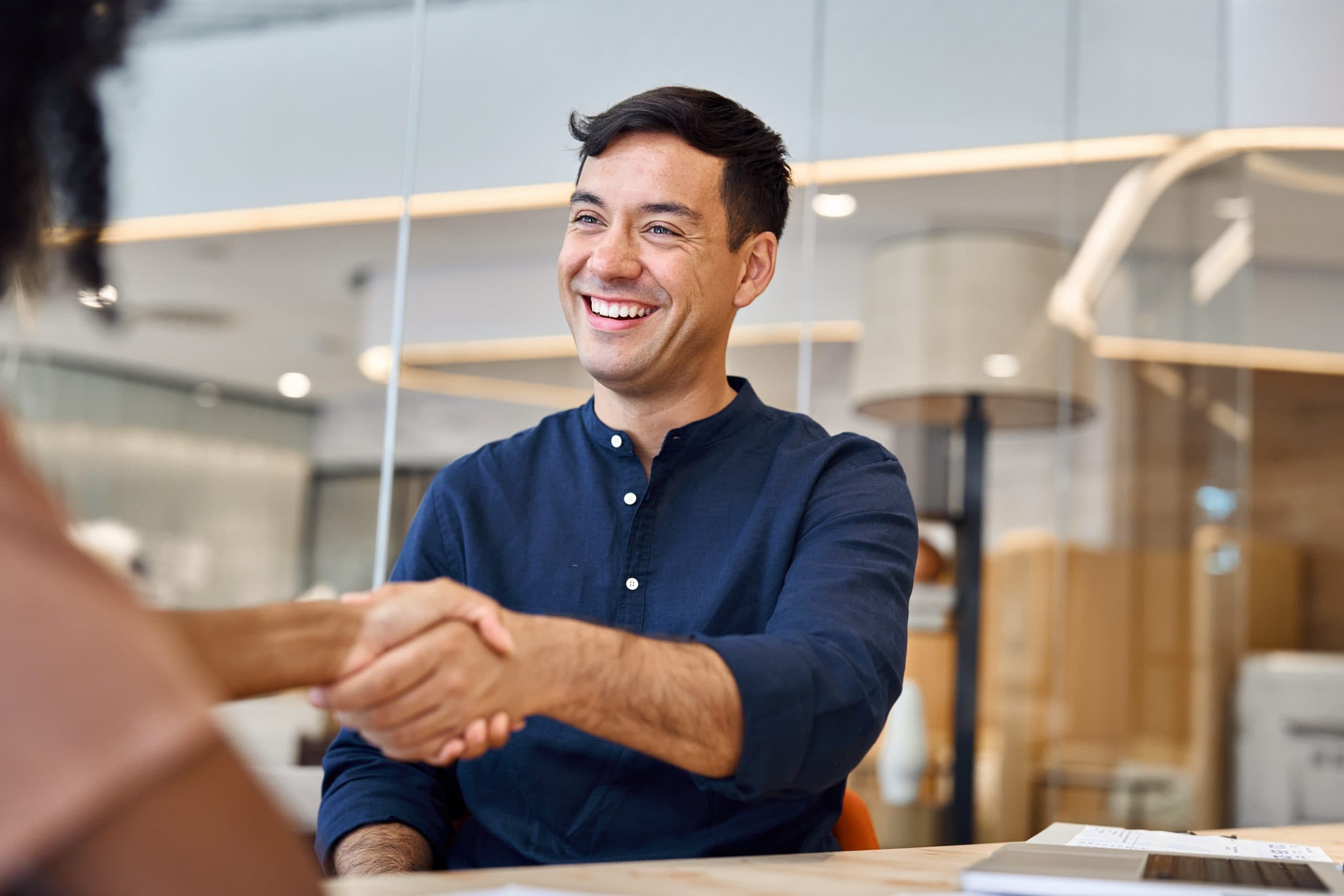 Business handshake: An office meeting and handshake illustrating business leaders’ optimism and focus on investments, expansion and hiring highlighted in the mid‑year survey.