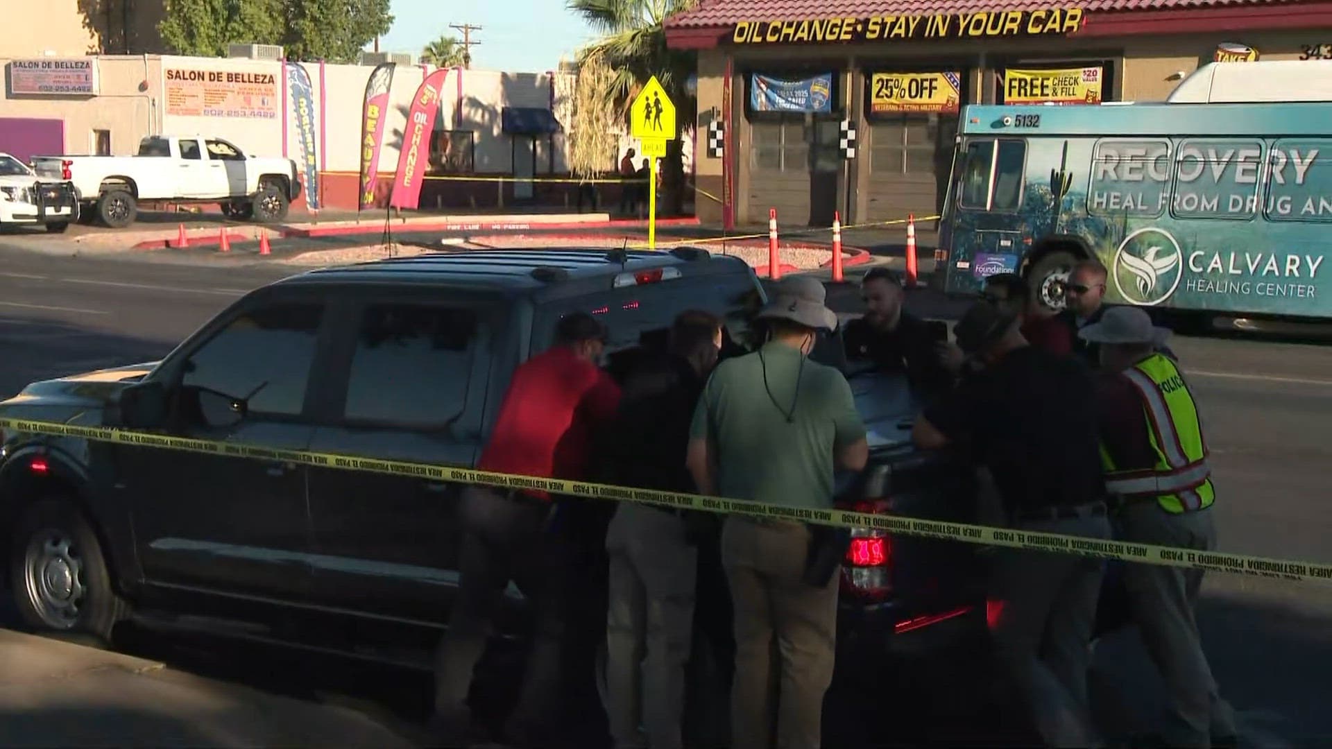 Emergency personnel and investigators gather around a pickup truck with police tape up outside an auto service near Bethany Home Road and 35th Avenue after a fatal bicycle crash.