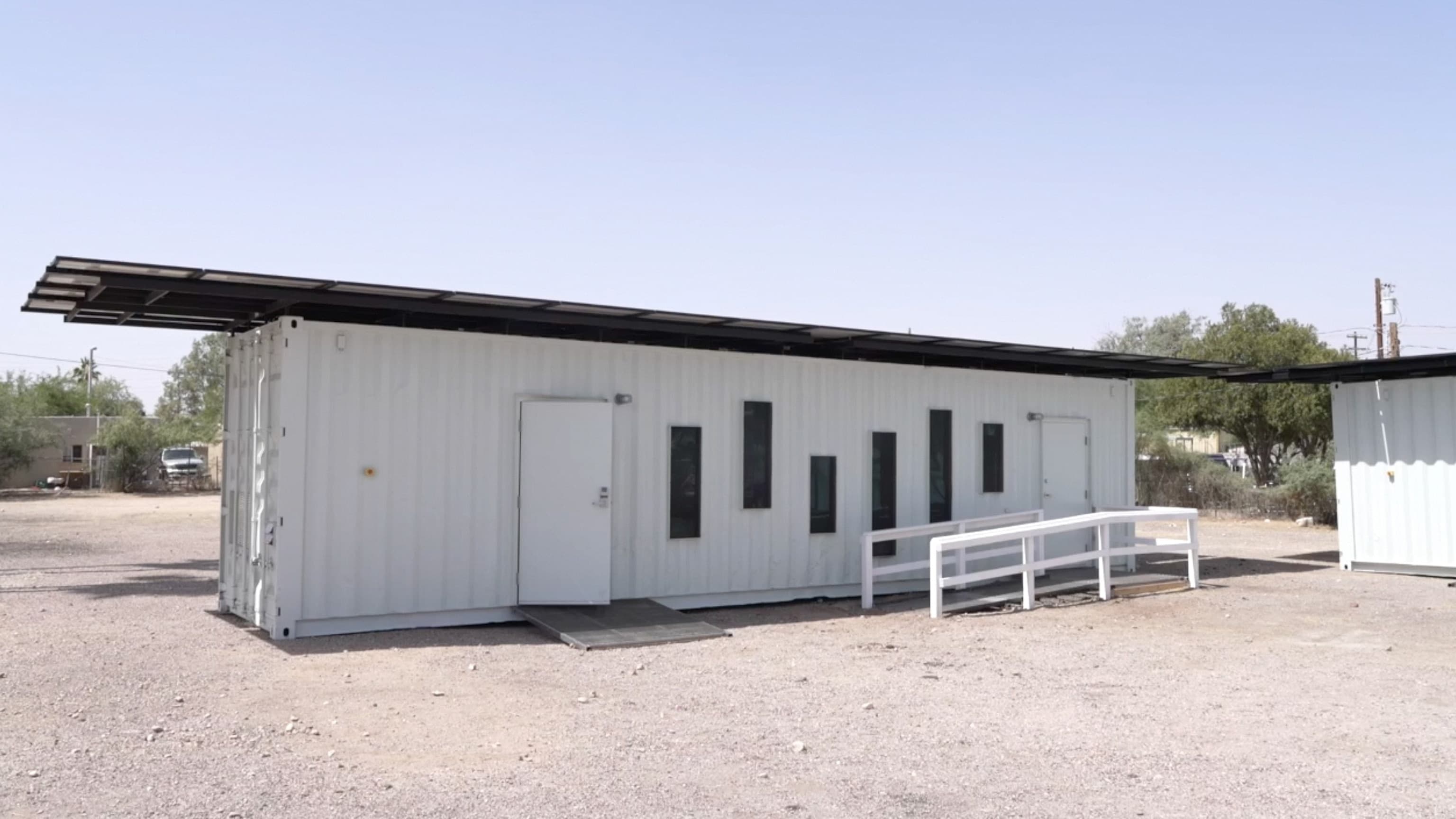 Side view of the COOLTainer at the South Side location, highlighting the accessible ramp, narrow windows and rooftop solar array.