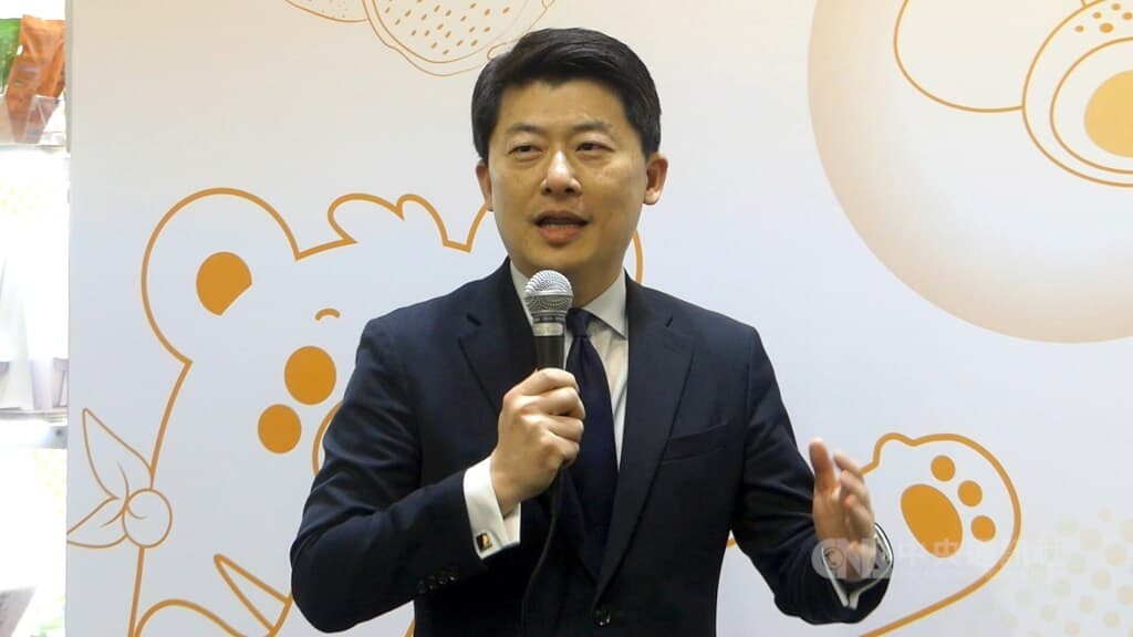 A Taiwanese envoy speaks into a microphone at a public event; Taipei has approved him as the new representative to Fiji, the article reports.