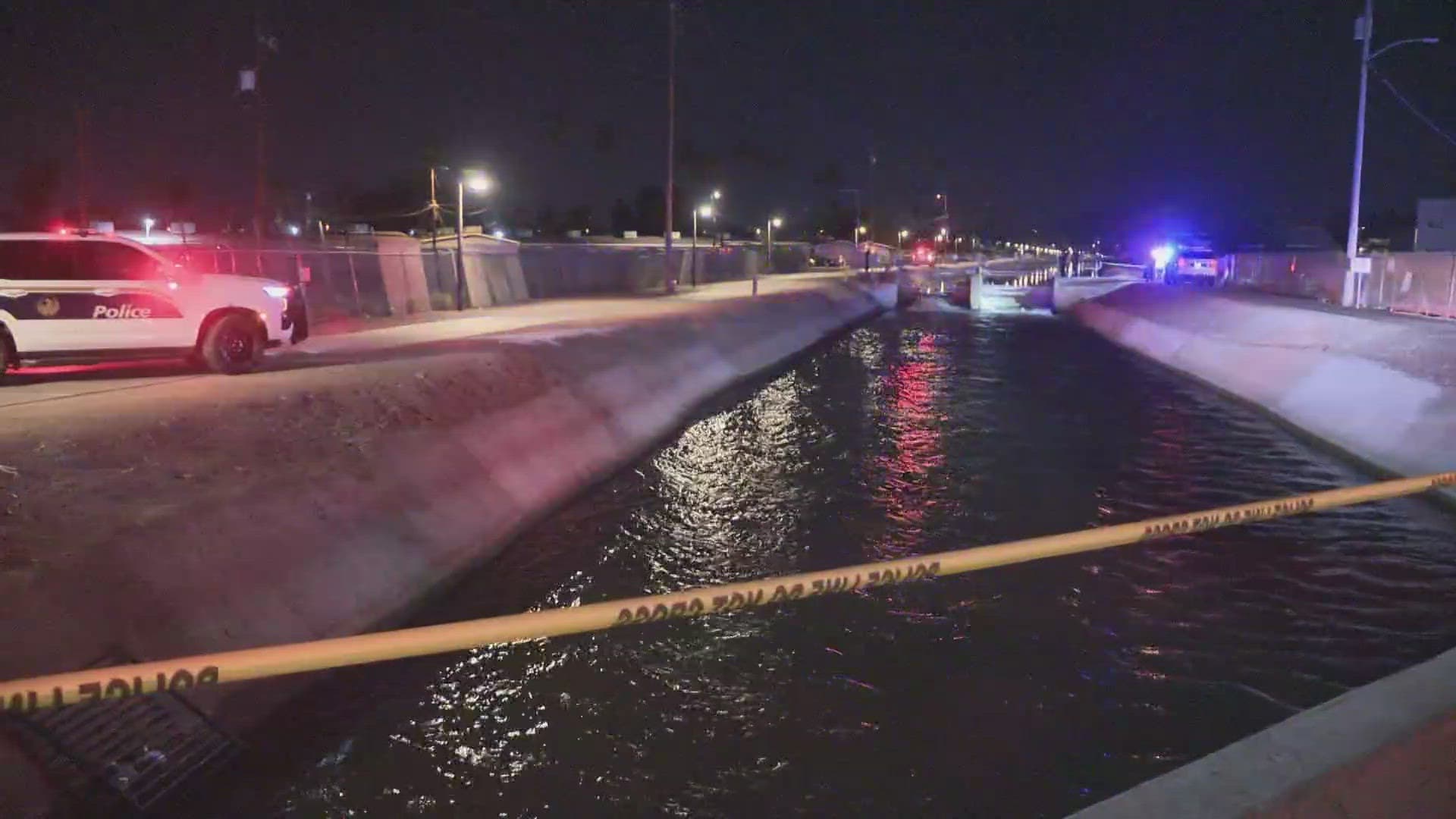 Police tape and emergency lights line a canal near 9th Street and Indian School Road during the investigation into a man's death.