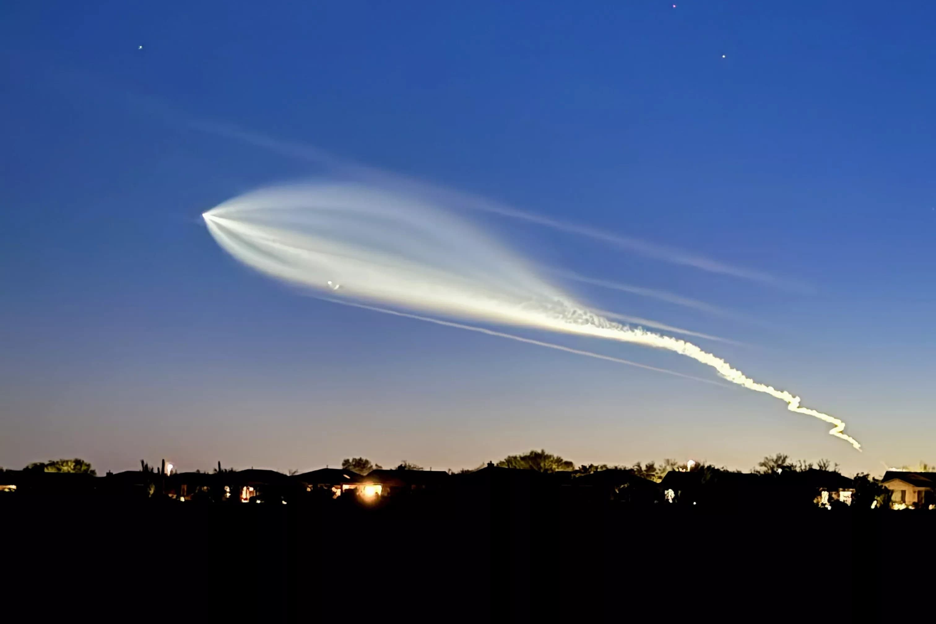 SpaceX Falcon 9 streaks across the twilight sky over Phoenix, its illuminated exhaust plume fanning out and visible to Valley residents during the July launch.